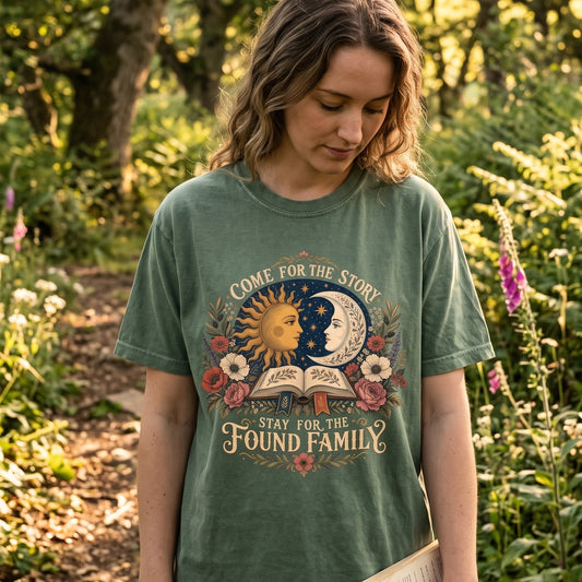 Woman wearing a Moss Comfort Colors found family book lover T-shirt with vintage celestial and floral artwork.