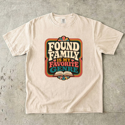 Ivory Comfort Colors found family book shirt featuring colourful retro typography and an open-book illustration.
