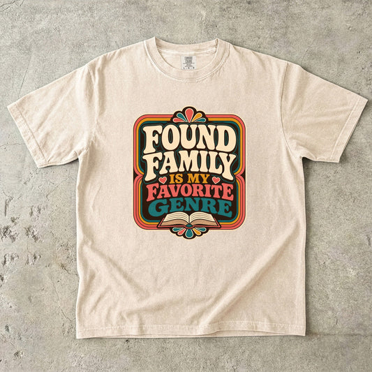 Ivory Comfort Colors found family book shirt featuring colourful retro typography and an open-book illustration.