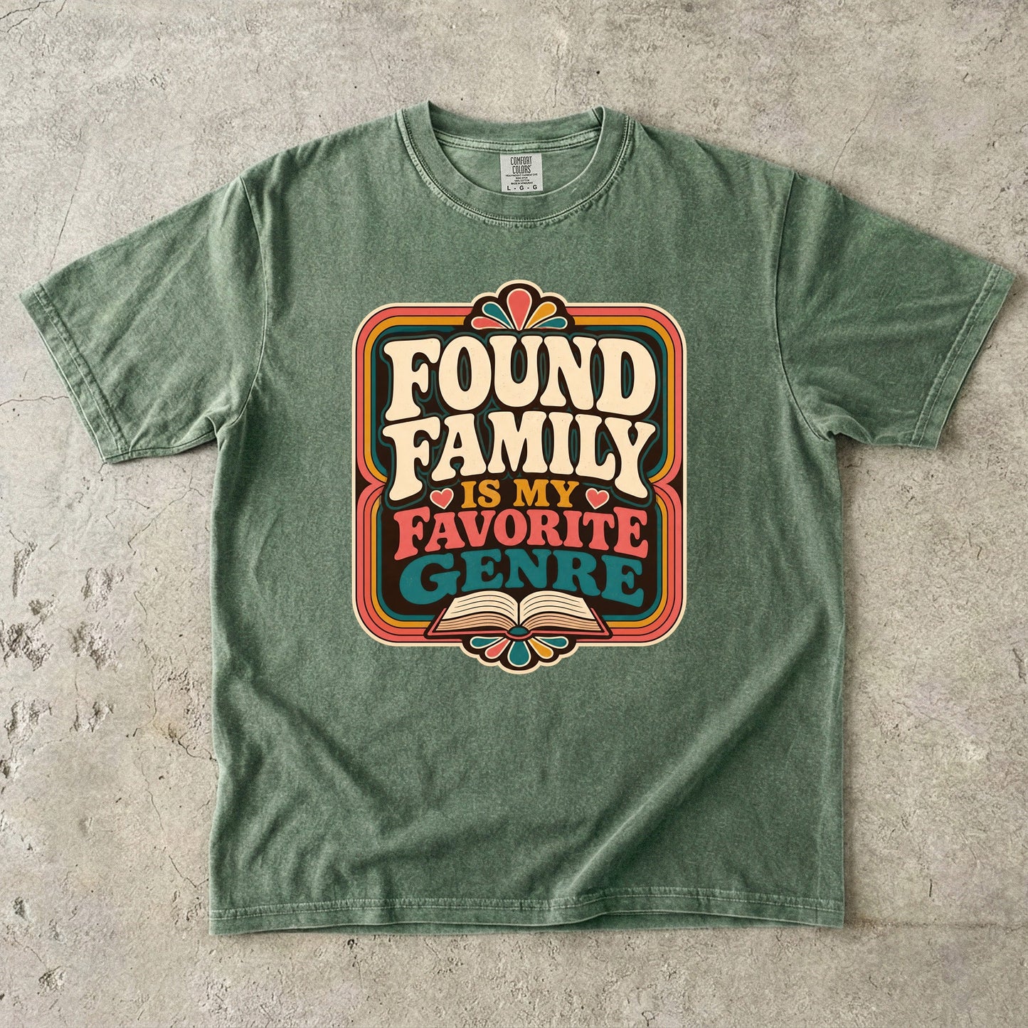 Moss Comfort Colors bookish T-shirt featuring the Found Family Is My Favorite Genre retro reader design.
