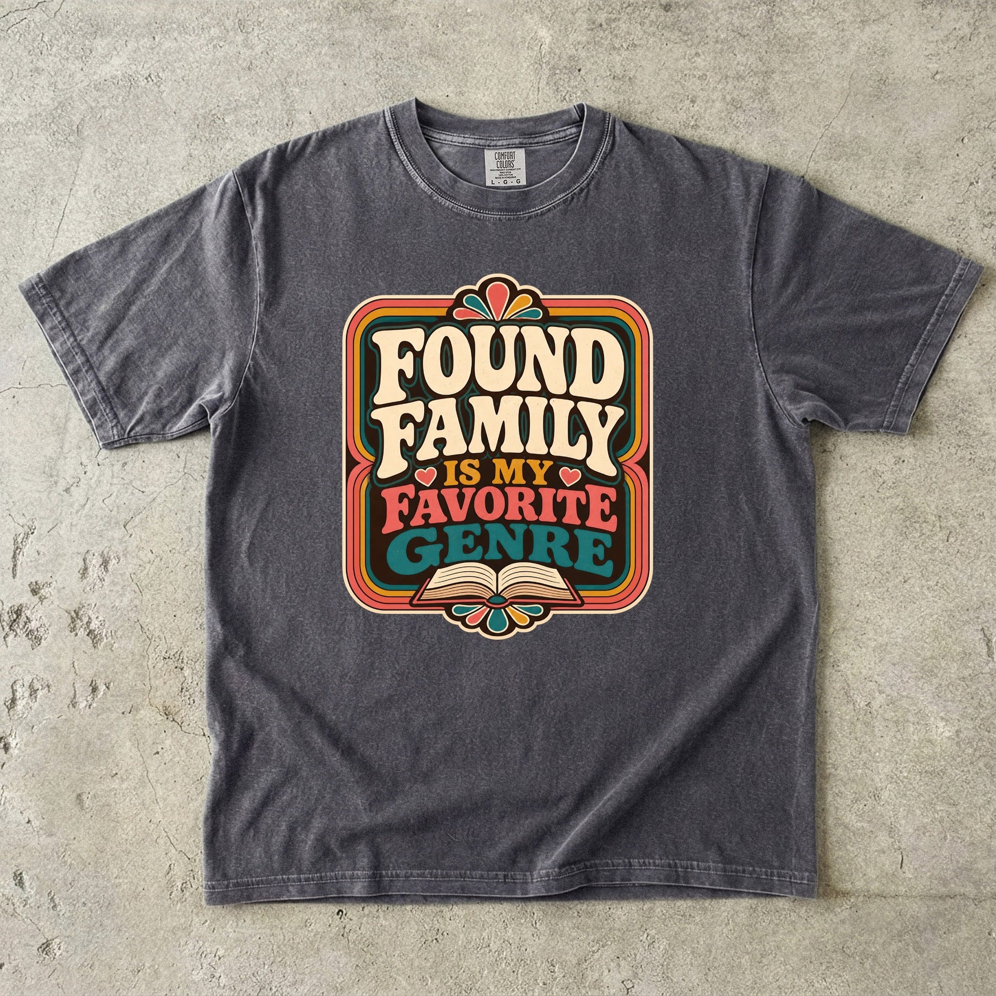 Pepper Comfort Colors book lover T-shirt featuring the retro Found Family Is My Favorite Genre design with an open book.
