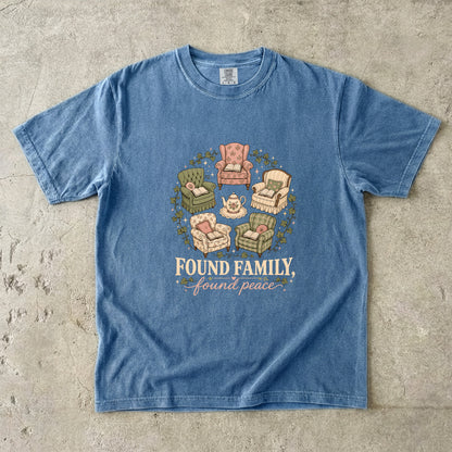 Blue Jean cozy reading T-shirt featuring Found Family, Found Peace with five vintage armchairs, open books, a floral teapot and ivy.