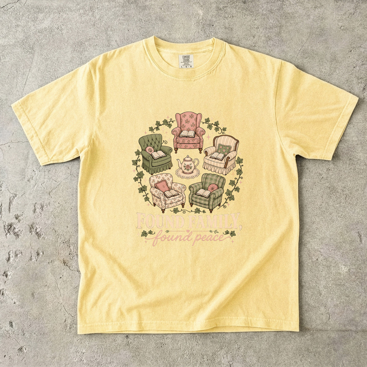 Butter cozy reading T-shirt featuring Found Family, Found Peace with five vintage armchairs, open books, a floral teapot and ivy.