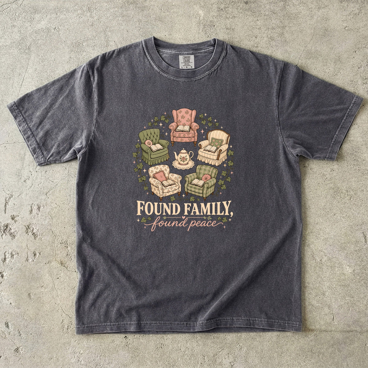 Pepper cozy reading T-shirt featuring Found Family, Found Peace with five vintage armchairs, open books, a floral teapot and ivy.