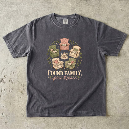 Pepper cozy reading T-shirt featuring Found Family, Found Peace with five vintage armchairs, open books, a floral teapot and ivy.