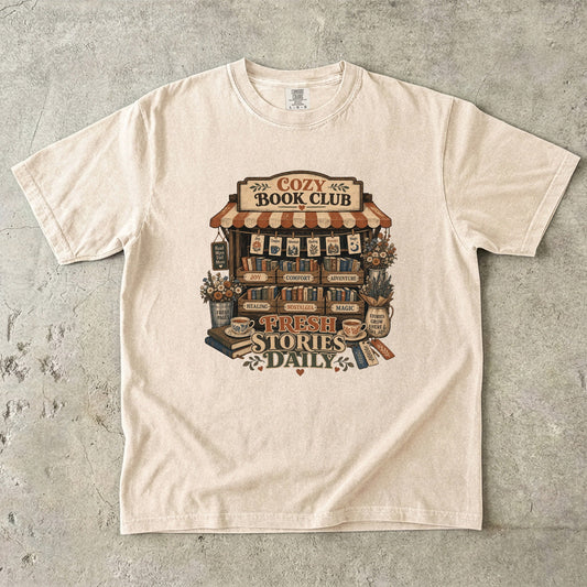 Fresh Stories Daily Book Lover Shirt on a Comfort Colors 1717 garment-dyed T-shirt in Ivory featuring a vintage book club stall with books, flowers, teacups and literary artwork.