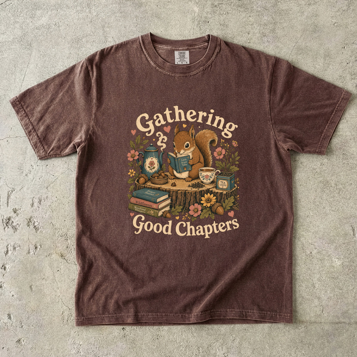 Gathering Good Chapters squirrel reading T-shirt in Espresso featuring a squirrel with a book, teapot, teacup, acorns and flowers