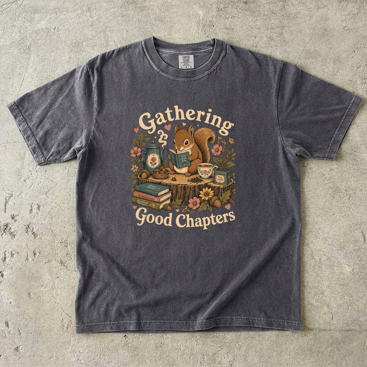 Gathering Good Chapters squirrel reading T-shirt in Pepper featuring a squirrel with a book, teapot, teacup, acorns and flowers