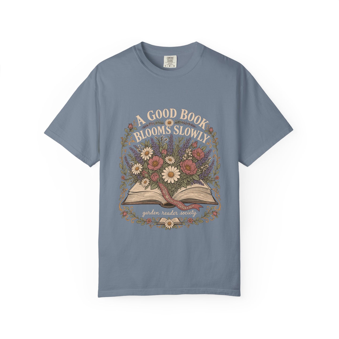 A Good Book Blooms Slowly botanical reading T-shirt with an open book and flowers on Blue Jean.