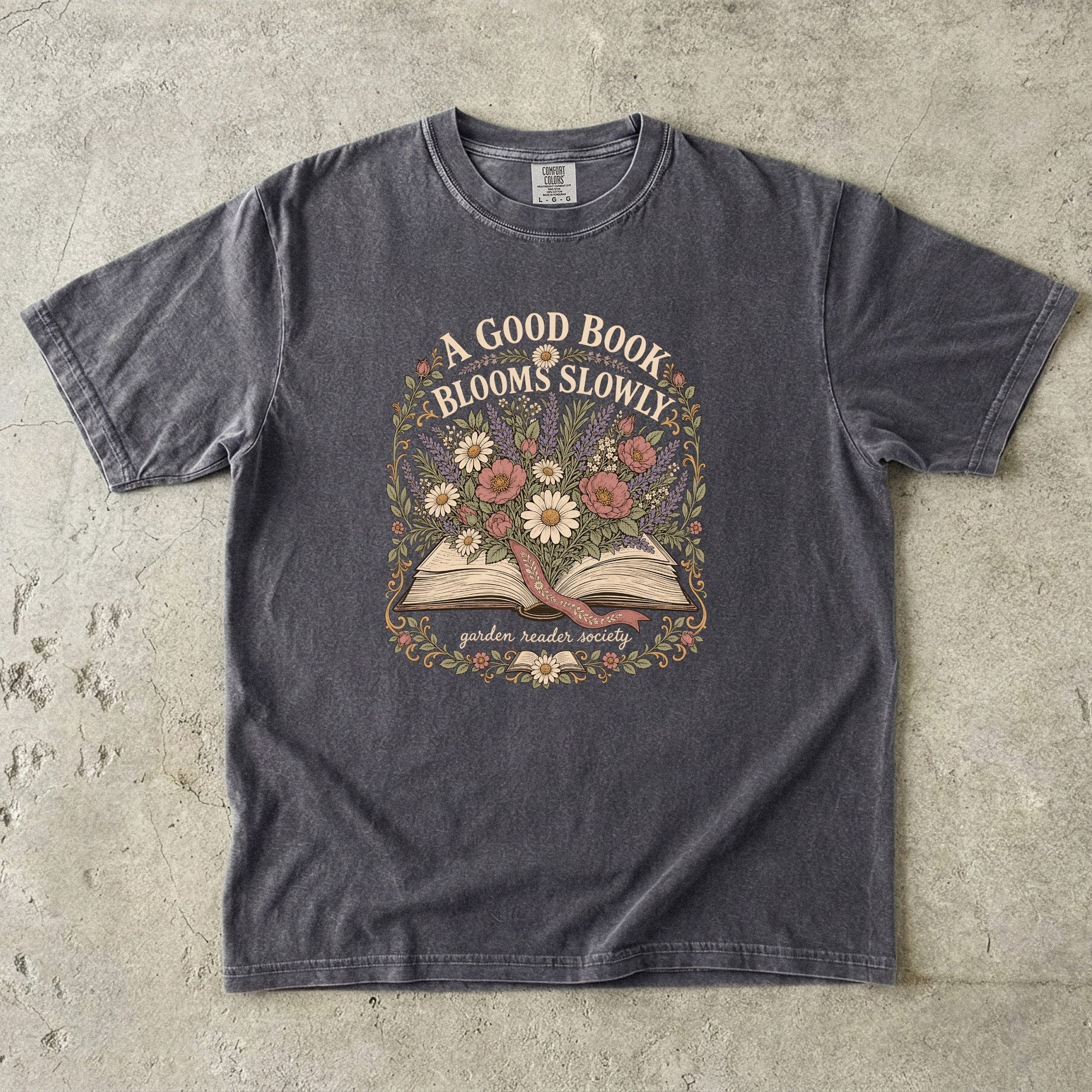 A Good Book Blooms Slowly botanical reading T-shirt with an open book and flowers on Pepper.