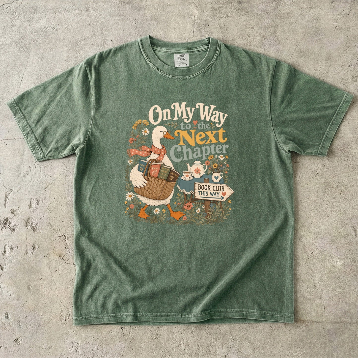 On My Way to the Next Chapter book club T-shirt with goose carrying a basket of books on Moss.
