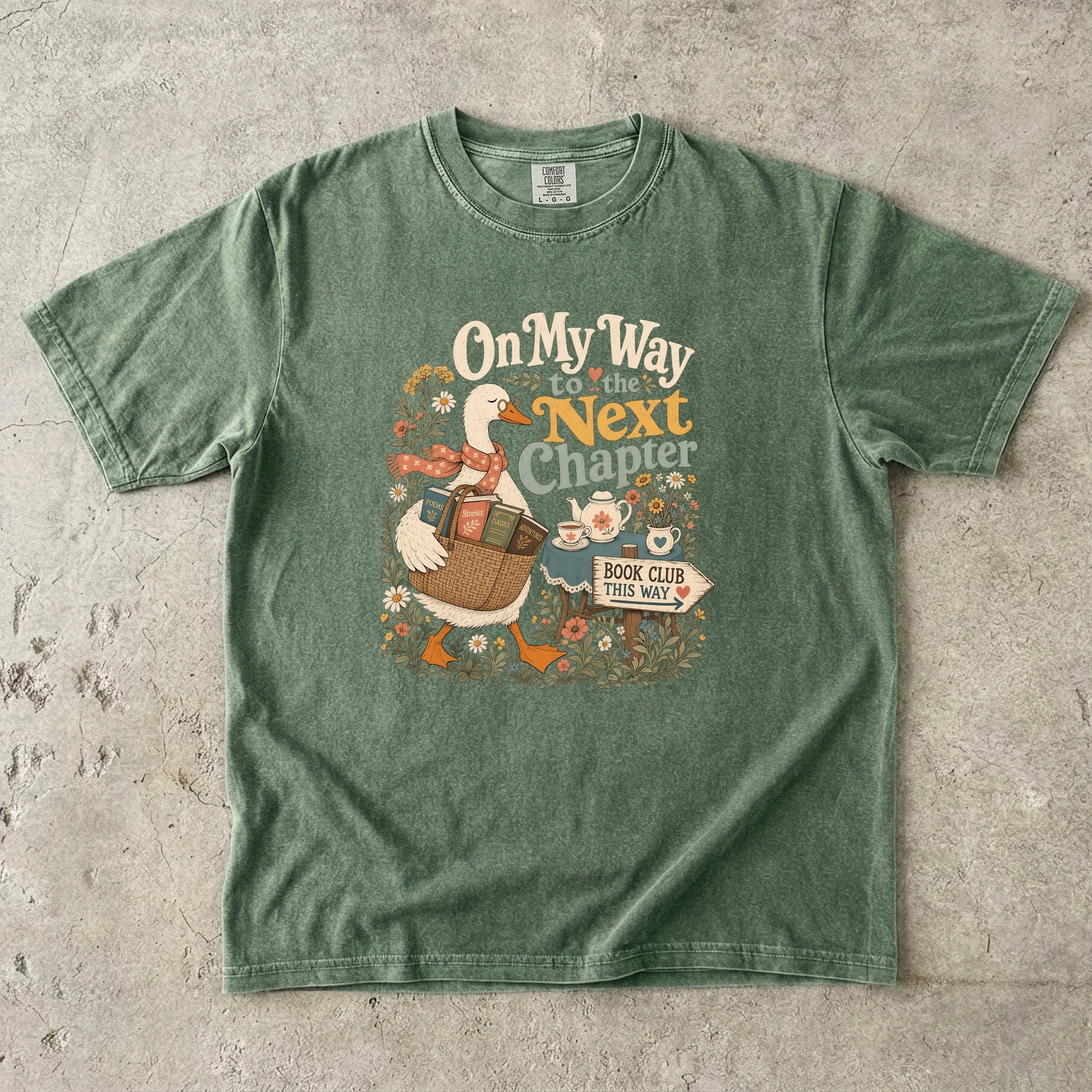 On My Way to the Next Chapter book club T-shirt with goose carrying a basket of books on Moss.