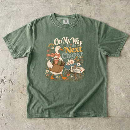 On My Way to the Next Chapter book club T-shirt with goose carrying a basket of books on Moss.