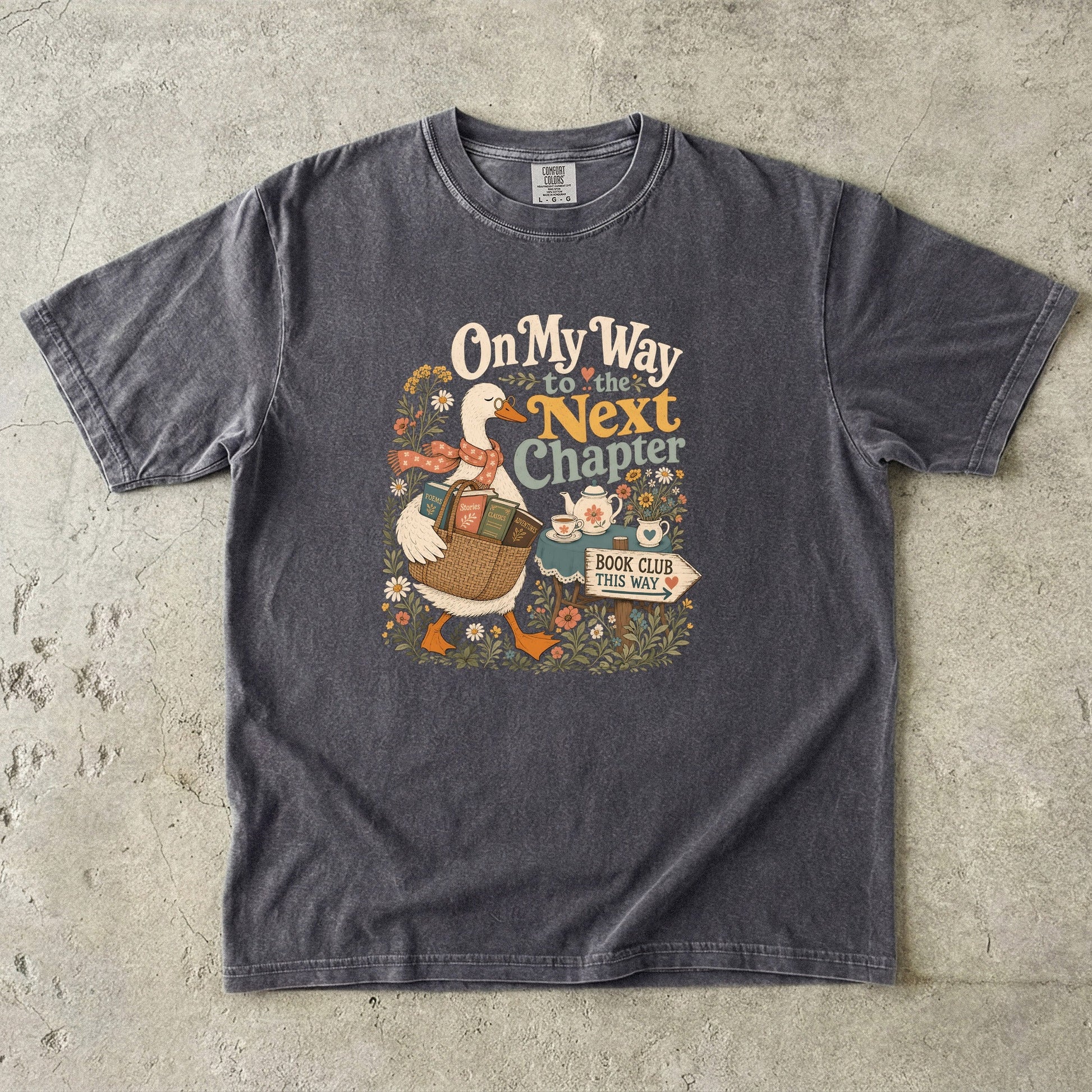 On My Way to the Next Chapter book club T-shirt with goose carrying a basket of books on Pepper.
