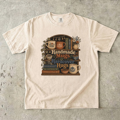 Front view of an Ivory Comfort Colors book lover shirt featuring handmade mugs, bookshelves and vintage cottagecore book artwork.