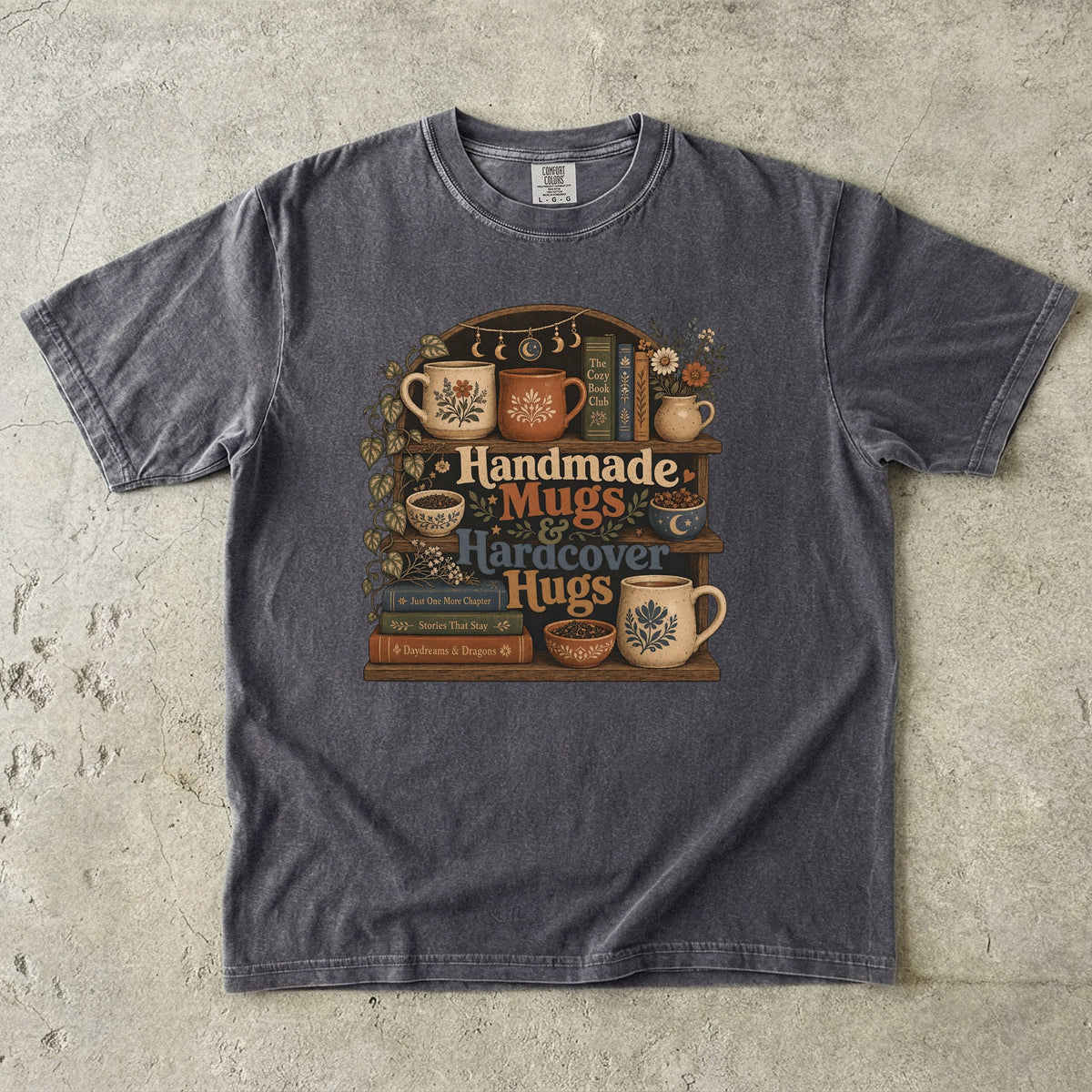 Handmade Mugs & Hardcover Hugs cozy reading T-shirt in Pepper featuring books, pottery mugs, flowers and a rustic shelf