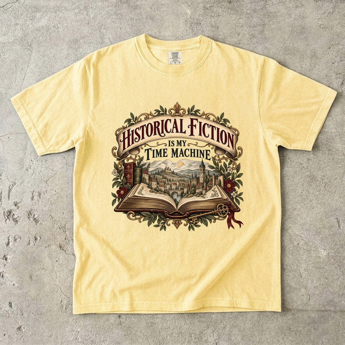 Butter T-shirt featuring “Historical Fiction Is My Time Machine” with an open book revealing an old-world town, ornate gold framing, antique books, leaves and burgundy flowers.