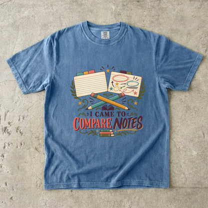 Blue Jean book club T-shirt with “I Came to Compare Notes,” tabbed note cards and crossed pencils