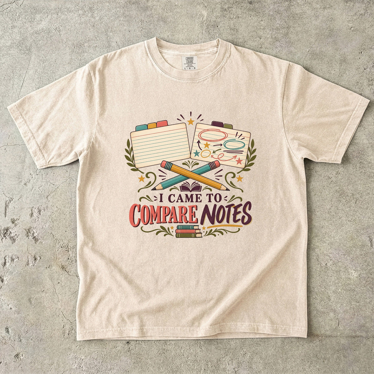 Ivory book club T-shirt with “I Came to Compare Notes,” tabbed note cards and crossed pencils