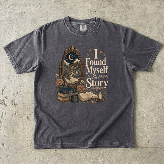 I Found Myself In A Story Book Lover Shirt printed on a Comfort Colors 1717 garment-dyed T-shirt in Pepper, featuring an antique mirror, moonlit cottage, books and vintage botanical artwork.