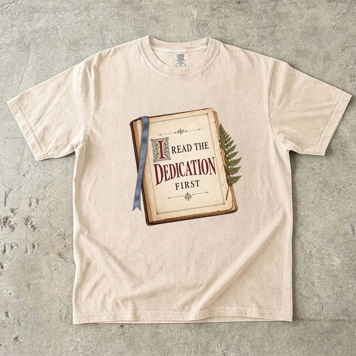 Ivory reader T-shirt with “I Read the Dedication First” inside an illustrated old book