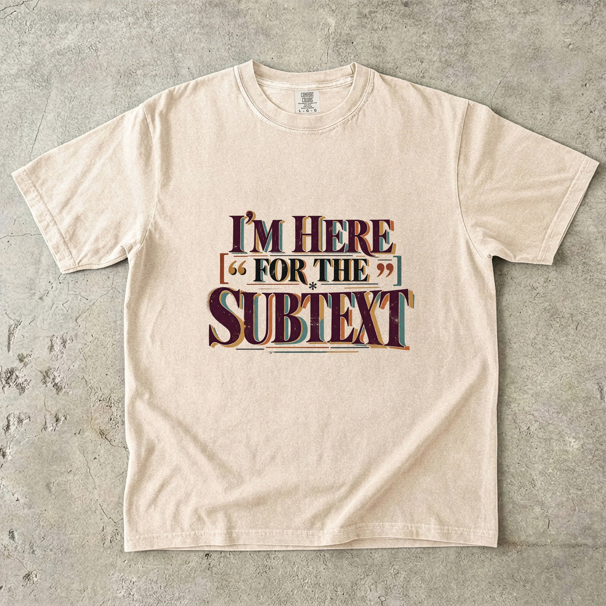 Ivory literary T-shirt with “I’m Here for the Subtext” in bold layered vintage lettering