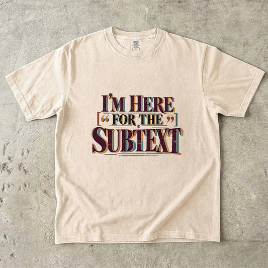 Ivory literary T-shirt with “I’m Here for the Subtext” in bold layered vintage lettering