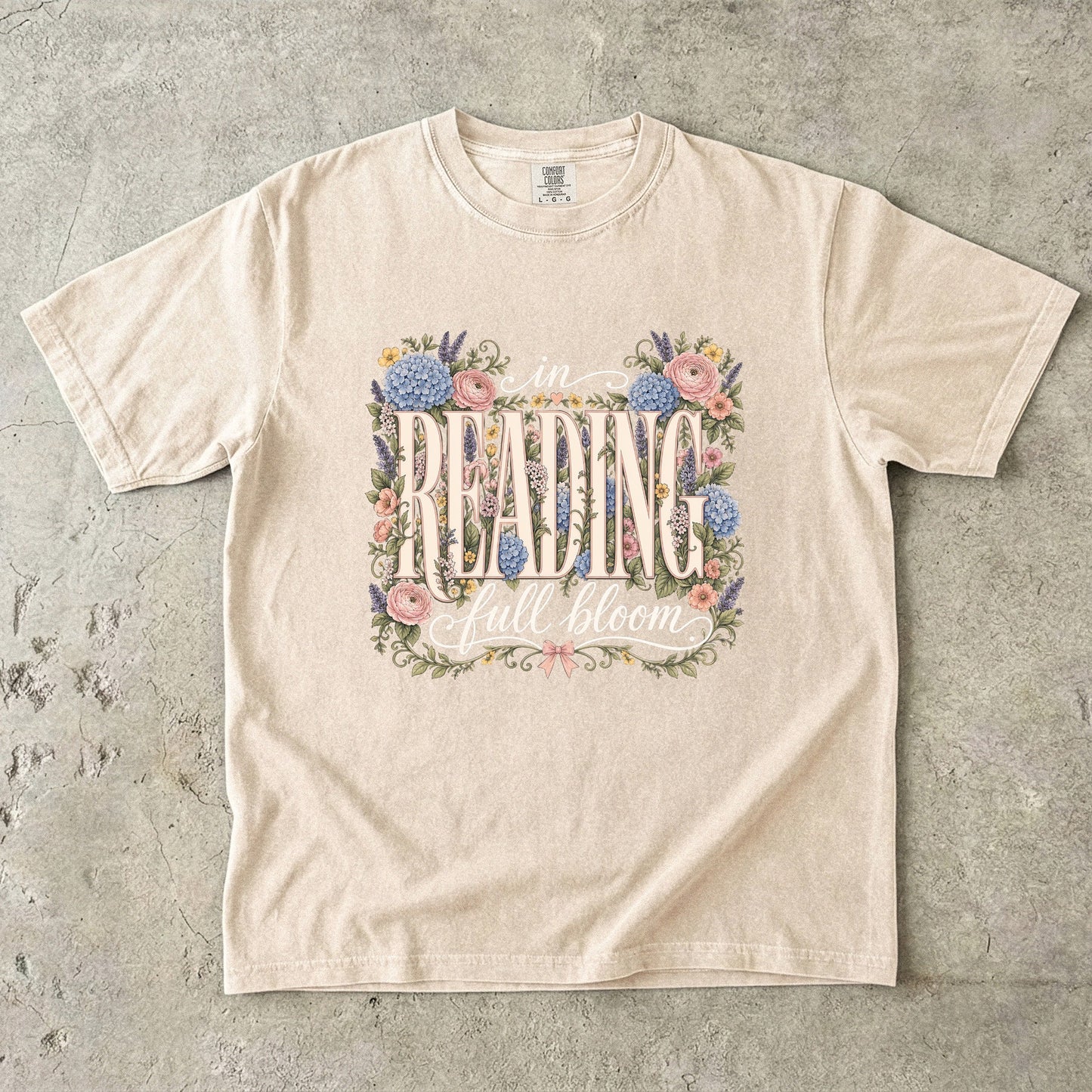 Ivory Comfort Colors bookish T-shirt featuring the In Reading, Full Bloom botanical reader design with vintage floral details.