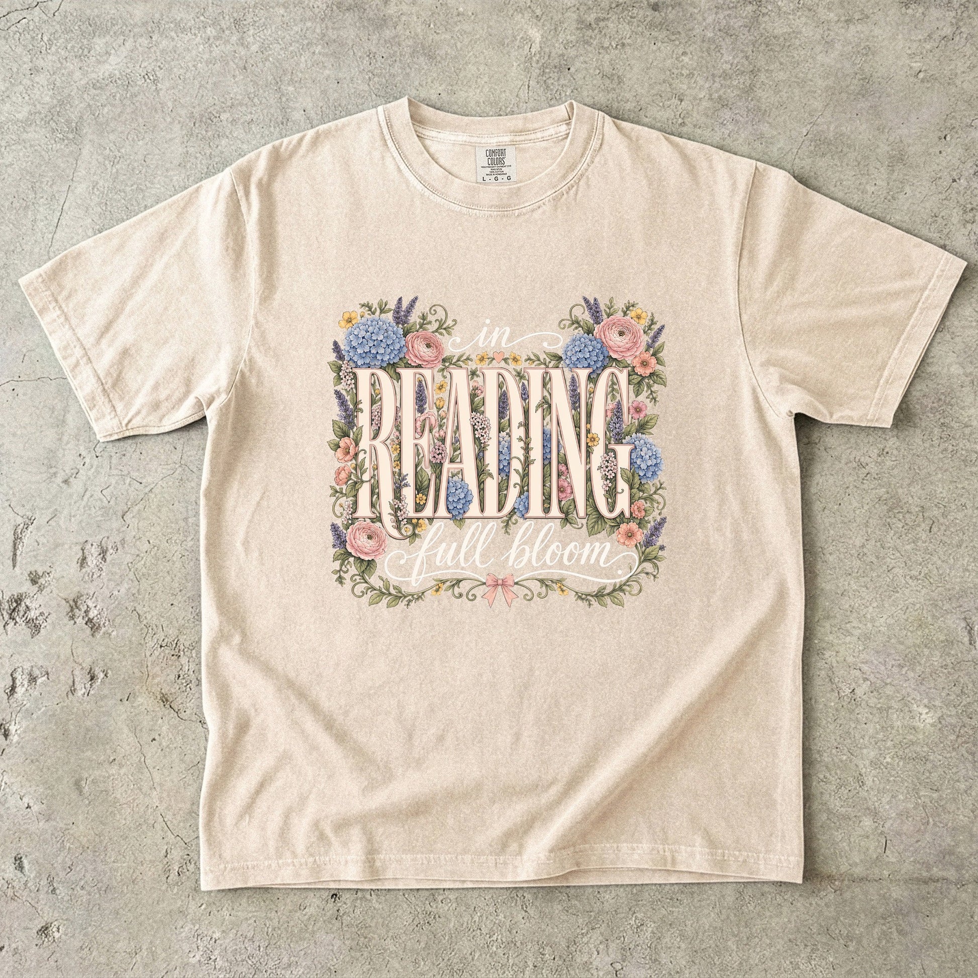 Ivory Comfort Colors bookish T-shirt featuring the In Reading, Full Bloom botanical reader design with vintage floral details.