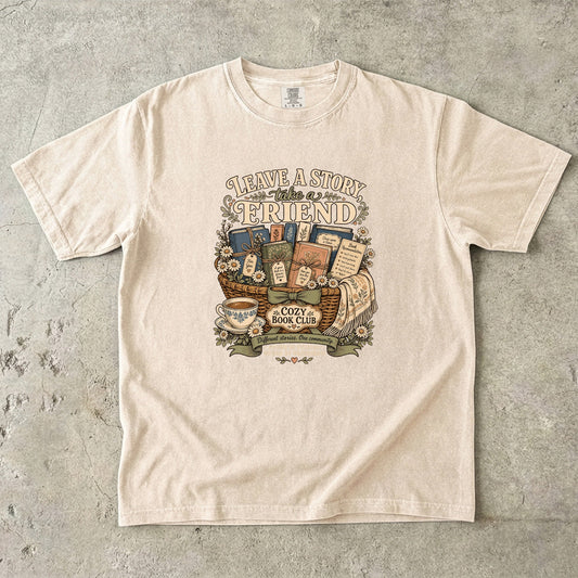 Leave a Story, Take a Friend book club T-shirt with gift basket of books and flowers on Ivory.