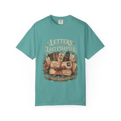 Front view of the Letters From the Last Chapter book club illustration printed on a Seafoam Comfort Colors T-shirt. 