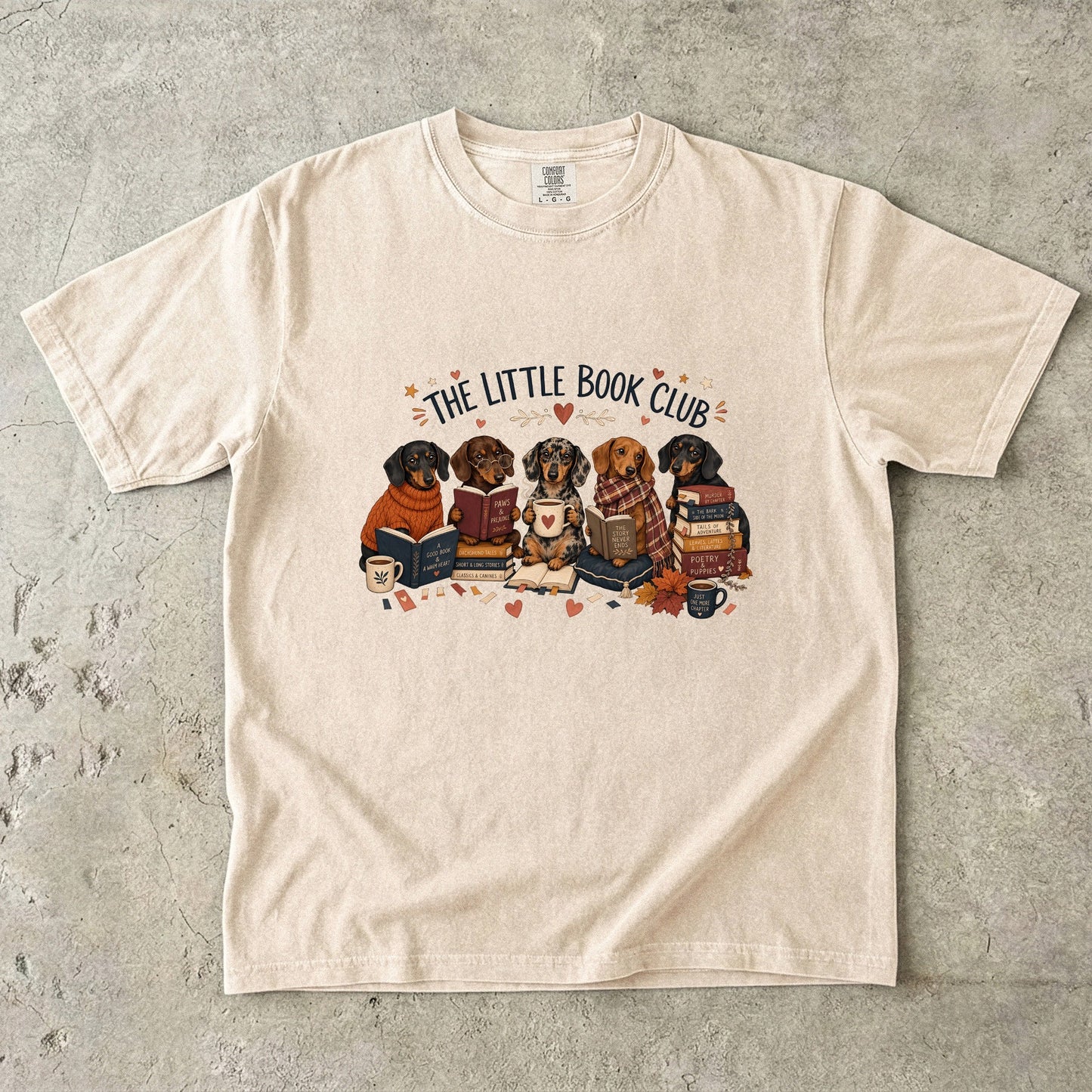Ivory Comfort Colors dog lover T-shirt featuring dachshunds gathered with books and mugs in The Little Book Club design.