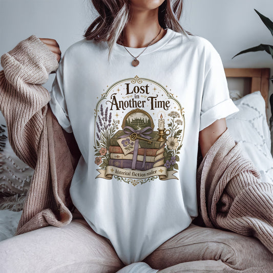 Woman wearing the Lost in Another Time Comfort Colors T-shirt featuring a vintage bookshop illustration inspired by timeless stories and cosy reading.