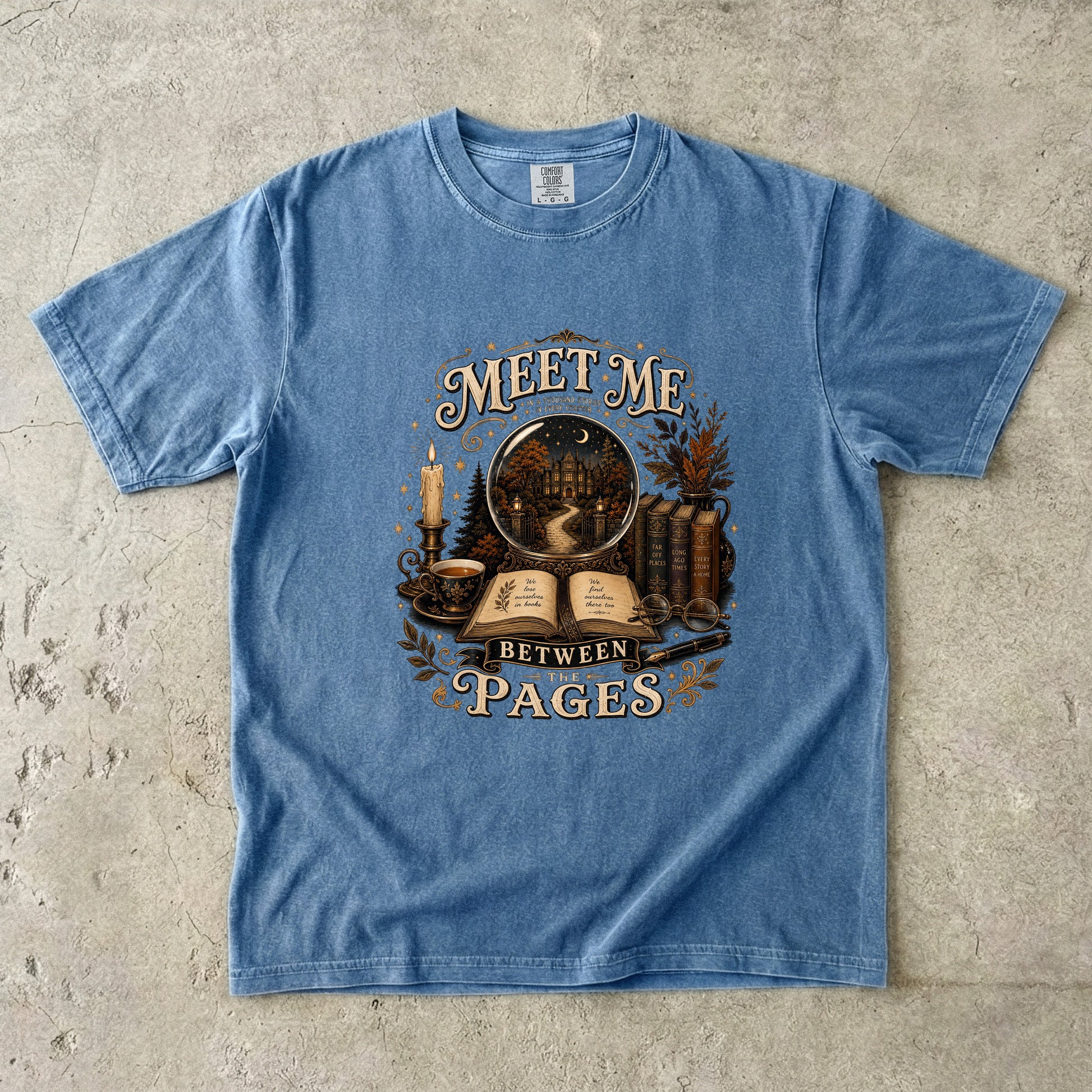 Blue Jean Comfort Colors book lover T-shirt featuring vintage books, candlelight and the Meet Me Between the Pages design.