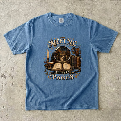 Blue Jean Comfort Colors book lover T-shirt featuring vintage books, candlelight and the Meet Me Between the Pages design.