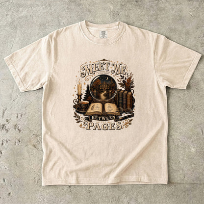 Ivory Comfort Colors book lover T-shirt with the Meet Me Between the Pages vintage literary illustration.