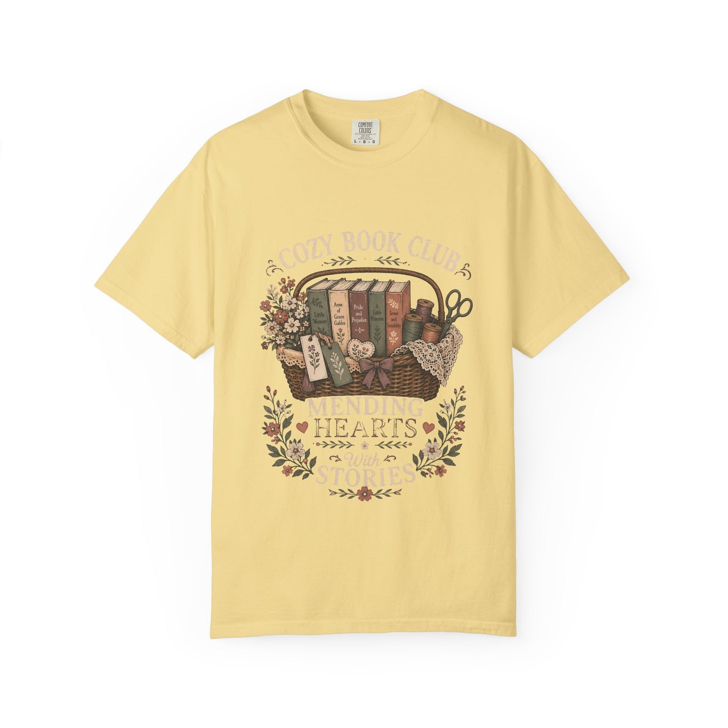 Mending Hearts With Stories book club T-shirt in Butter featuring classic books, sewing notions, flowers and a woven basket