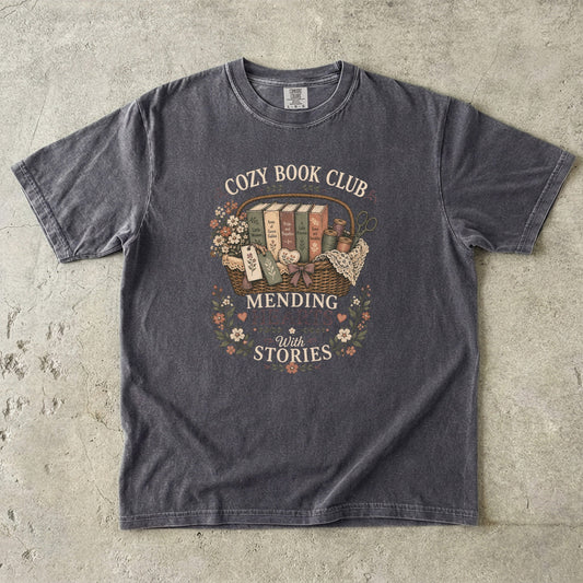 Mending Hearts With Stories book club T-shirt in Pepper featuring classic books, sewing notions, flowers and a woven basket
