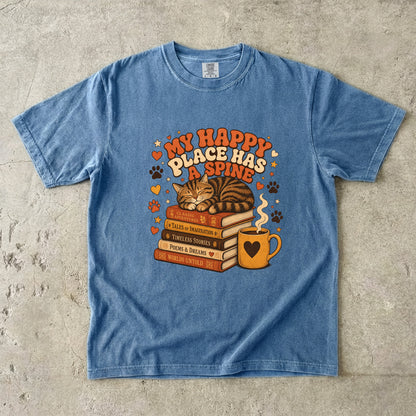 Blue Jean cat book lover T-shirt featuring a sleeping tabby on stacked books beside a steaming mug with hearts, stars and paw prints.