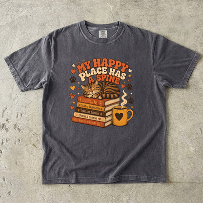 Pepper cat book lover T-shirt featuring a sleeping tabby on stacked books beside a steaming mug with hearts, stars and paw prints.