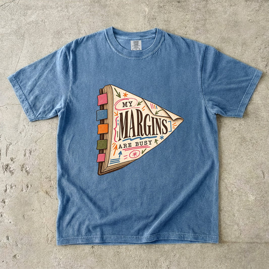 Blue Jean reading T-shirt with “My Margins Are Busy” on a tabbed book with colourful annotations
