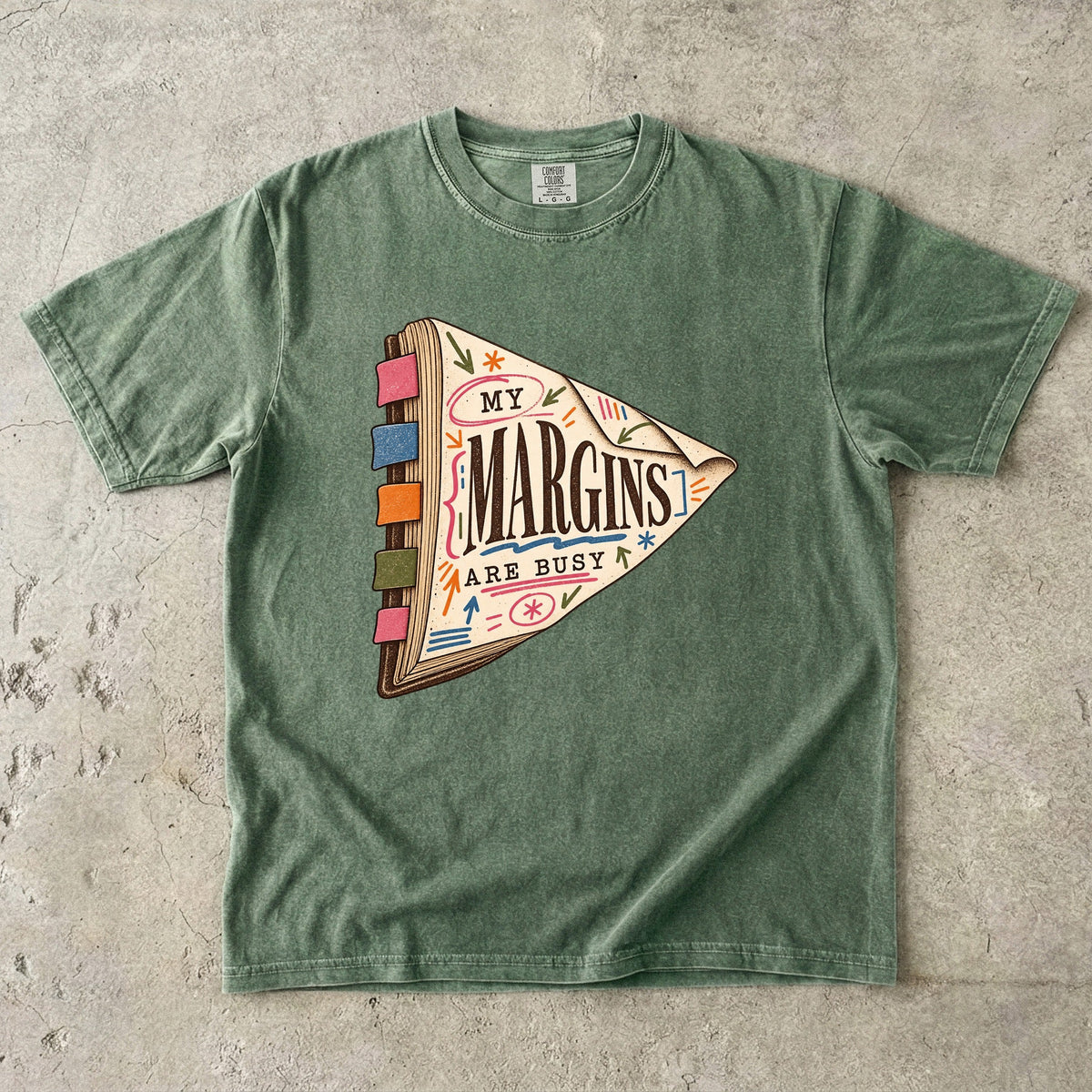 Moss reading T-shirt with “My Margins Are Busy” on a tabbed book with colourful annotations