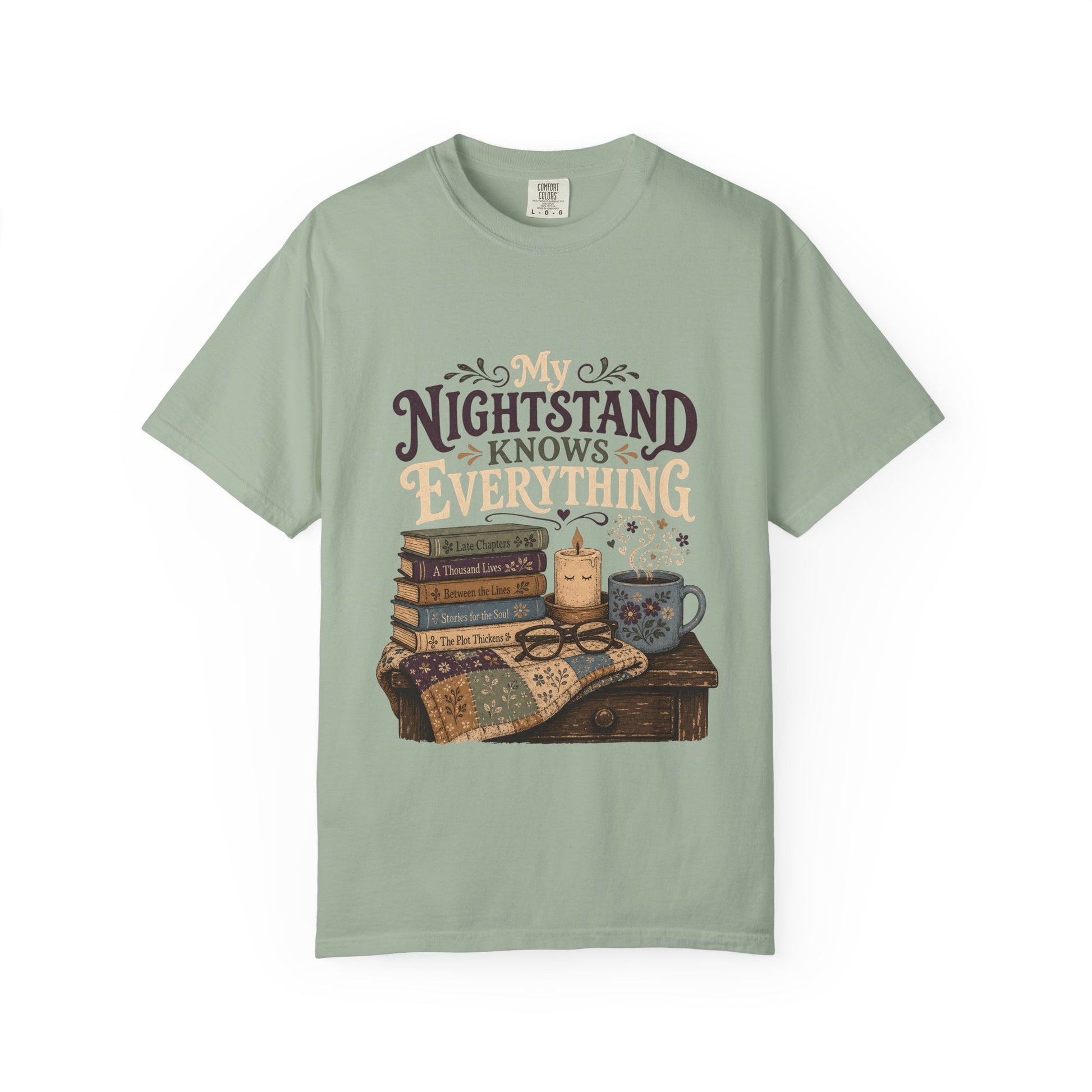 Front view of the My Nightstand Knows Everything Book Lover T-Shirt in Bay featuring vintage books, candlelight and a cosy reading illustration.


