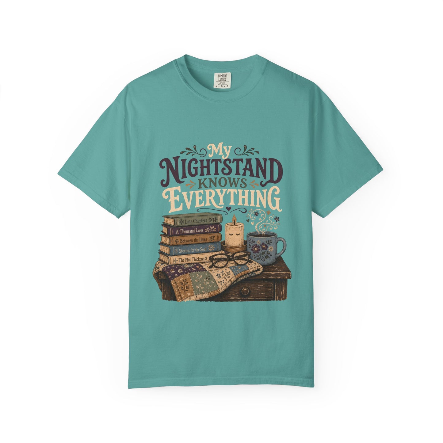Front view of the My Nightstand Knows Everything Book Lover T-Shirt in Seafoam with a vintage book stack, candle, mug and cosy reading artwork.


