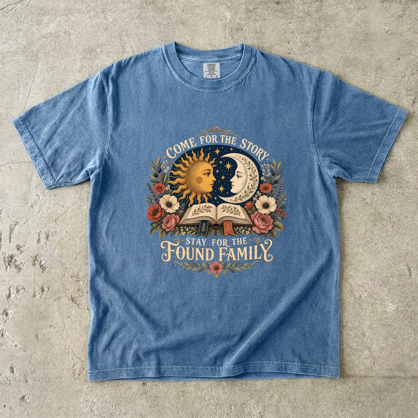 Blue Jean Comfort Colors found family book shirt featuring vintage sun, moon, flowers and open book artwork.