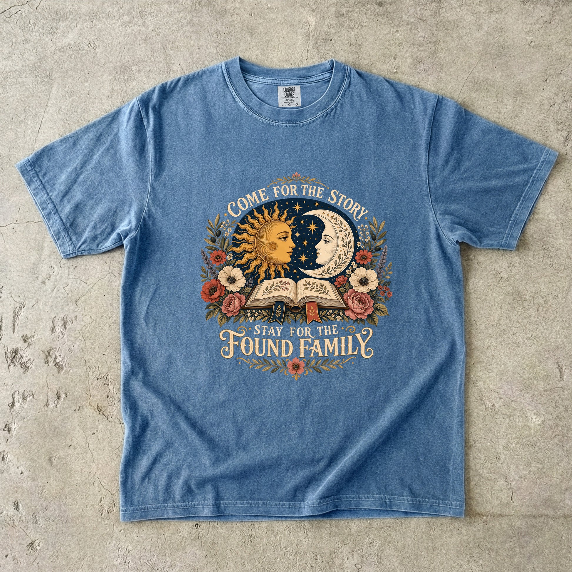 Blue Jean Comfort Colors found family book shirt featuring vintage sun, moon, flowers and open book artwork.