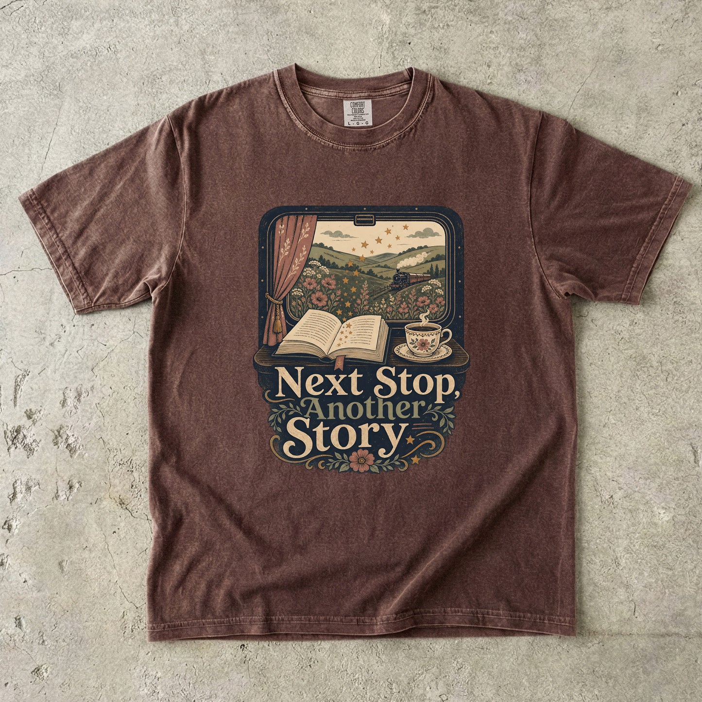 Front view of an Espresso Comfort Colors Book Lover Shirt featuring an open book, steam train and cozy travel-inspired literary artwork.