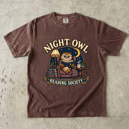 Espresso T-shirt featuring “Night Owl Reading Society” with a spectacled owl reading in an armchair, a lamp, books, mug, crescent moon and stars.