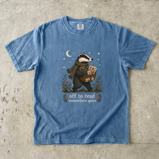 Off to Read Somewhere Quiet badger reading T-shirt in Blue Jean featuring a scarfed badger carrying books and tea