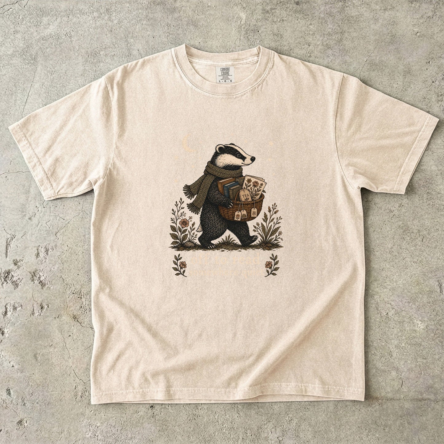 Off to Read Somewhere Quiet badger reading T-shirt in Ivory featuring a scarfed badger carrying books and tea